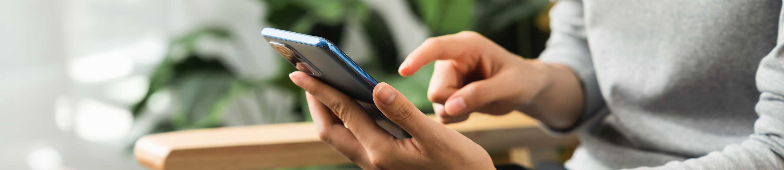 woman sat down using a phone - contact us